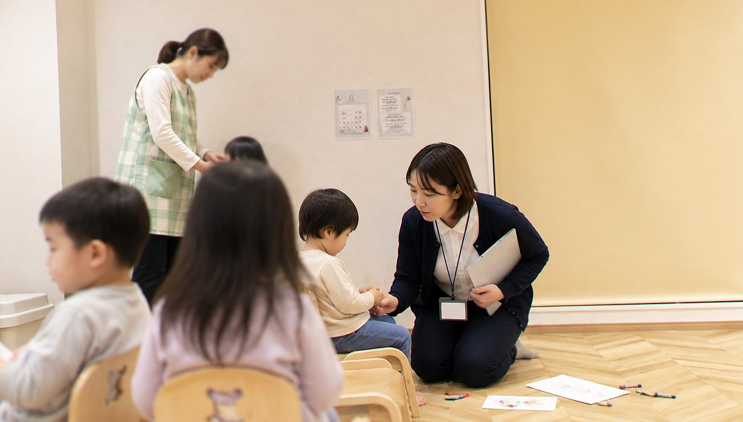 園を訪問し、担任の先生と一緒にお子さまの様子を見ている場面